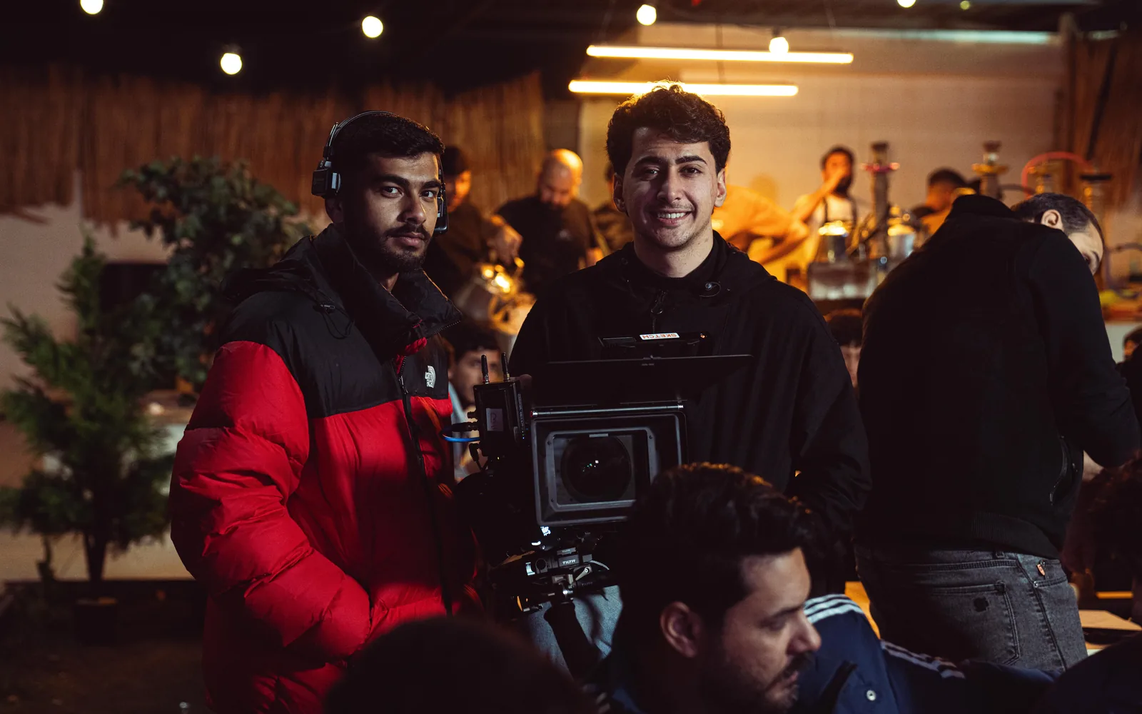 Una troupe che gira un video con la telecamera dentro un locale la sera