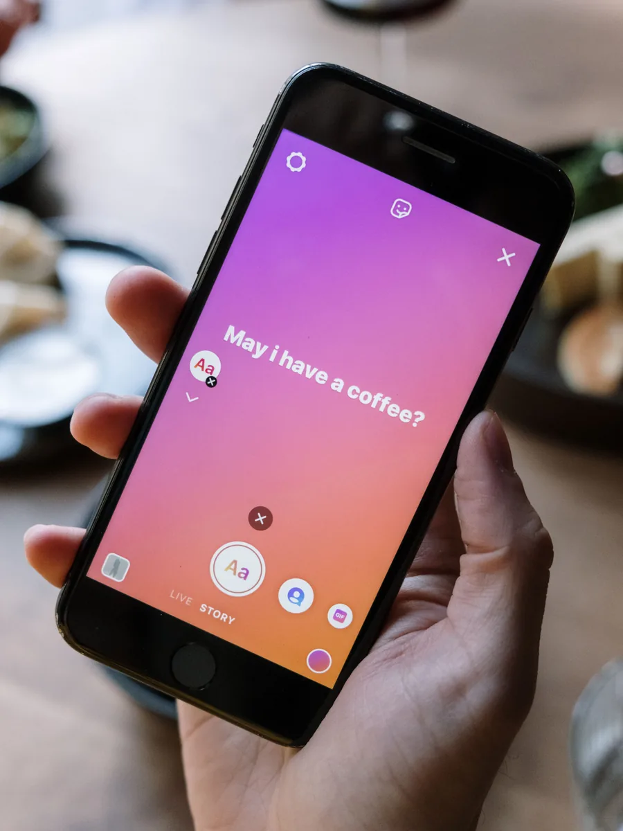 Mano che tiene uno smartphone con una storia social aperta